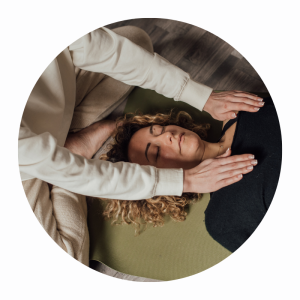 Woman receiving adult Reiki healing, with the practitioners hands held beside her head.