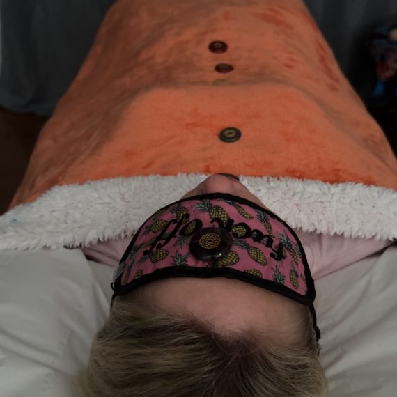Client Laying on Therapy Couch/Bed receiving Reiki energy healing with Crystals placed along the Chakras