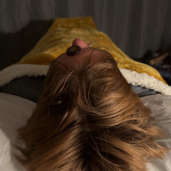 Client lays on therapy couch/Bed with Crystals placed along the chakras whilst receiving Reiki Energy Healing