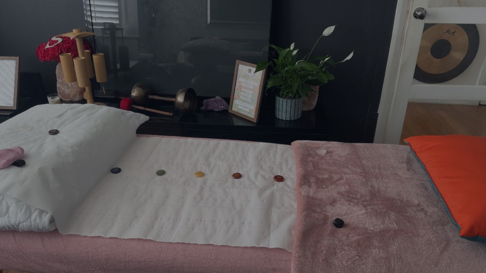 Reiki Couch/ bed with Pink blanket Crystals and pillows, ready for a client.